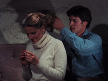 Movie still from “The Evil Dead” (1981), directed by Sam Raimi – A man and a woman sitting next to each other; Close Up shot, Over the shoulder angle