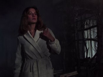 Movie still from “The Evil Dead” (1981), directed by Sam Raimi – A woman in a white robe standing in a dark room; Medium shot, Low angle