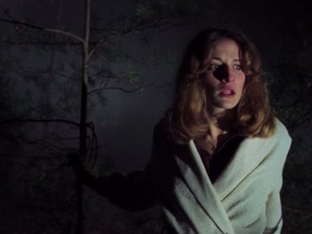 Movie still from “The Evil Dead” (1981), directed by Sam Raimi – A woman in a white robe standing next to a tree; Close Up shot, Low angle