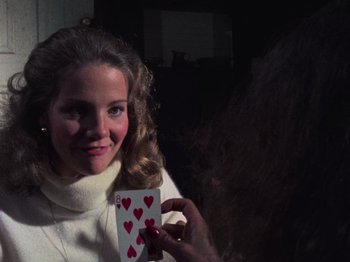 Movie still from “The Evil Dead” (1981), directed by Sam Raimi – A woman is holding a card with hearts on it; Close Up shot, Over the shoulder angle