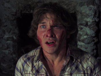 Movie still from “The Evil Dead” (1981), directed by Sam Raimi – A man with a knife in his mouth; Close Up shot, Low angle