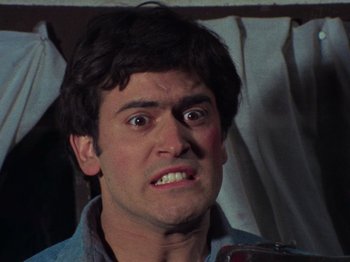 Movie still from “The Evil Dead” (1981), directed by Sam Raimi – A person making a funny face; Close Up shot, Low angle