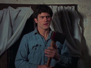 Movie still from “The Evil Dead” (1981), directed by Sam Raimi – A man holding an axe in his hands; Close Up shot, Low angle