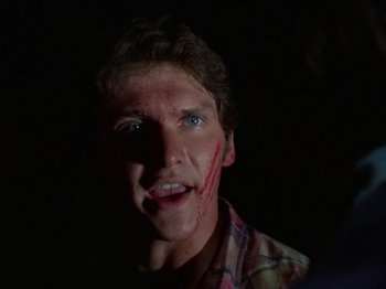 Movie still from “The Evil Dead” (1981), directed by Sam Raimi – A young man with blood all over his face; Close Up shot, Over the shoulder angle