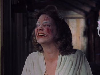 Movie still from “The Evil Dead” (1981), directed by Sam Raimi – A woman laughing with blood all over her face; Close Up shot, Low angle