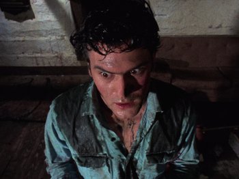 Movie still from “The Evil Dead” (1981), directed by Sam Raimi – A man with wet hair and a blue shirt; Close Up shot, Overhead angle