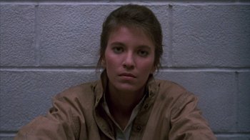 Movie still from “Day of the Dead” (1985), directed by George A. Romero – A woman in a brown jacket sitting in front of a brick wall; Close Up shot, Low angle