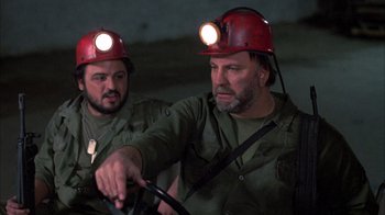 Movie still from “Day of the Dead” (1985), directed by George A. Romero – A couple of men wearing hard hats working on a construction site; Close Up shot, Low angle