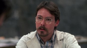 Movie still from “Day of the Dead” (1985), directed by George A. Romero – A person wearing glasses and a jacket; Close Up shot, Over the shoulder angle