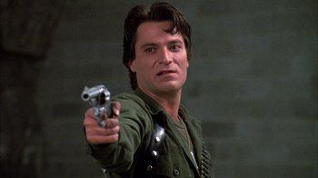 Movie still from “Day of the Dead” (1985), directed by George A. Romero – A person holding a gun; Close Up shot, Low angle