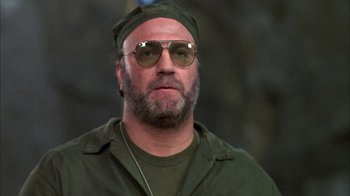 Movie still from “Day of the Dead” (1985), directed by George A. Romero – A person wearing sunglasses and a hat; Close Up shot, Low angle