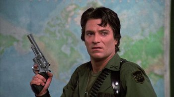 Movie still from “Day of the Dead” (1985), directed by George A. Romero – A person holding a gun in a room; Close Up shot, Low angle