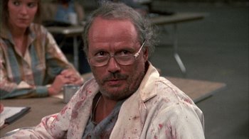 Movie still from “Day of the Dead” (1985), directed by George A. Romero – An older man with a beard and glasses; Close Up shot, Low angle