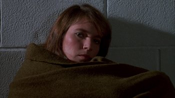 Movie still from “Day of the Dead” (1985), directed by George A. Romero – A woman wrapped in a blanket looking at the camera; Close Up shot, High angle