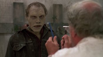 Movie still from “Day of the Dead” (1985), directed by George A. Romero – A man is looking at himself in the mirror while holding a tooth brush; Close Up shot, Over the shoulder angle