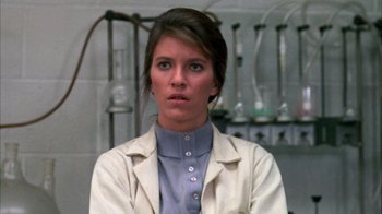 Movie still from “Day of the Dead” (1985), directed by George A. Romero – A woman wearing a lab coat in front of a wall; Close Up shot, Low angle