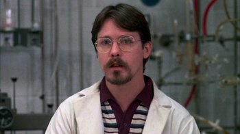Movie still from “Day of the Dead” (1985), directed by George A. Romero – A man in a white lab coat and striped shirt; Close Up shot, Low angle