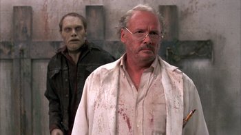 Movie still from “Day of the Dead” (1985), directed by George A. Romero – A man in a white shirt and a man in a black shirt; Close Up shot, Over the shoulder angle