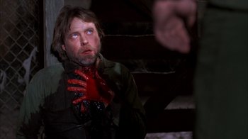 Movie still from “Day of the Dead” (1985), directed by George A. Romero – A man holding a bloody hand over his face; Close Up shot, Over the shoulder angle