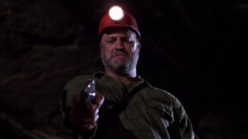 Movie still from “Day of the Dead” (1985), directed by George A. Romero – A man holding a gun while wearing a hard hat and holding a flashlight; Close Up shot, Low angle