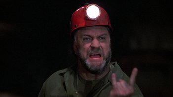Movie still from “Day of the Dead” (1985), directed by George A. Romero – A man wearing a red hard hat with a light on his head; Close Up shot, Low angle
