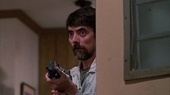 Movie still from “Day of the Dead” (1985), directed by George A. Romero – A man holding a gun in a room; Close Up shot, Low angle