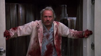 Movie still from “Day of the Dead” (1985), directed by George A. Romero – A man with blood on his face and arms; Medium shot, Low angle