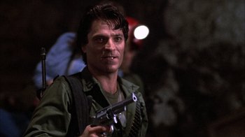 Movie still from “Day of the Dead” (1985), directed by George A. Romero – A person holding a gun in a room; Close Up shot, Low angle