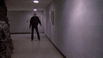 Movie still from “Day of the Dead” (1985), directed by George A. Romero – A man with a cane stands in the hallway of a building; Wide shot, Low angle