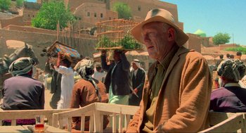 Movie still from “The Exorcist” (1973), directed by William Friedkin – An old man wearing a cowboy hat sitting on a bench; Medium shot, Over the shoulder angle