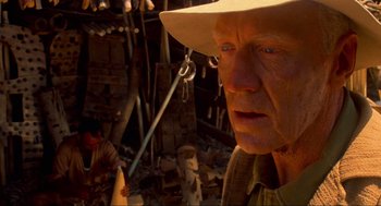 Movie still from “The Exorcist” (1973), directed by William Friedkin – An older man wearing a hat and a hat with blue eyes; Close Up shot, Over the shoulder angle