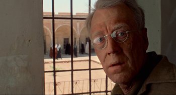 Movie still from “The Exorcist” (1973), directed by William Friedkin – An older man wearing glasses looking out of a window; Close Up shot, Over the shoulder angle