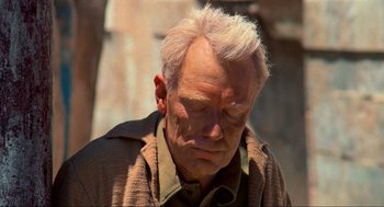 Movie still from “The Exorcist” (1973), directed by William Friedkin – An old man with white hair is looking down; Close Up shot, Over the shoulder angle