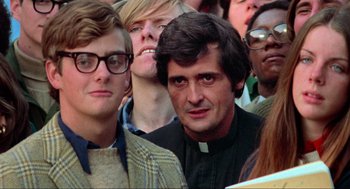 Movie still from “The Exorcist” (1973), directed by William Friedkin – A group of people that are standing in a crowd; Close Up shot, Low angle