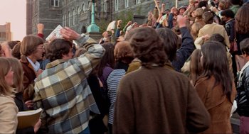 Movie still from “The Exorcist” (1973), directed by William Friedkin – A group of people standing in the street with their hands raised; Wide shot, High angle