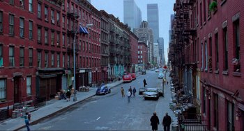 Movie still from “The Exorcist” (1973), directed by William Friedkin – People walking down a street in a city with tall buildings in the background; Extreme Wide shot, High angle