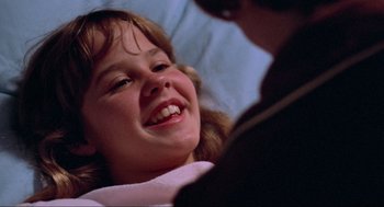 Movie still from “The Exorcist” (1973), directed by William Friedkin – A young girl smiling at the camera while sitting in a dentist's chair; Close Up shot, Over the shoulder angle