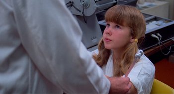 Movie still from “The Exorcist” (1973), directed by William Friedkin – A young girl sitting in front of an older man; Close Up shot, Over the shoulder angle