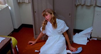 Movie still from “The Exorcist” (1973), directed by William Friedkin – A girl in a white dress sitting on the floor; Medium shot, High angle