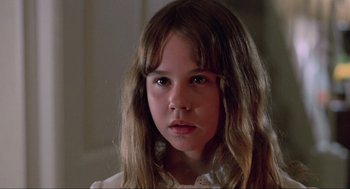 Movie still from “The Exorcist” (1973), directed by William Friedkin – A young girl with long hair is looking at the camera; Close Up shot, Low angle