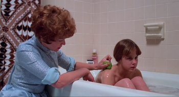 Movie still from “The Exorcist” (1973), directed by William Friedkin – A woman in a bath tub with a child in a bathtub; Medium shot, High angle