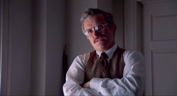 Movie still from “The Exorcist” (1973), directed by William Friedkin – An older man wearing glasses and wearing a vest; Close Up shot, Low angle