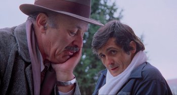 Movie still from “The Exorcist” (1973), directed by William Friedkin – A man in a hat and a man in a jacket and tie; Close Up shot, Low angle