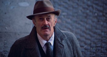 Movie still from “The Exorcist” (1973), directed by William Friedkin – An older man wearing a hat and a coat; Close Up shot, Low angle