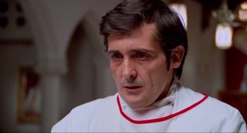 Movie still from “The Exorcist” (1973), directed by William Friedkin – A person wearing a white shirt; Close Up shot, Low angle