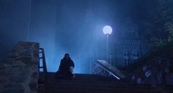 Movie still from “The Exorcist” (1973), directed by William Friedkin – A man sitting on the steps in the dark; Extreme Wide shot, Low angle