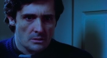 Movie still from “The Exorcist” (1973), directed by William Friedkin – A man's face in a dark room; Close Up shot, Low angle