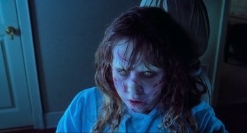 Movie still from “The Exorcist” (1973), directed by William Friedkin – A young girl with a bloody face is sitting in a chair; Close Up shot, High angle