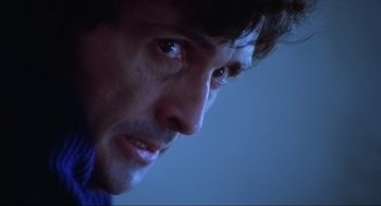Movie still from “The Exorcist” (1973), directed by William Friedkin – A man's face in a dark room; Close Up shot, Low angle