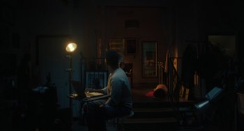 Movie still from “The Exorcist: Believer” (2023), directed by David Gordon Green – A man sitting at a table with a laptop; Wide shot, Low angle